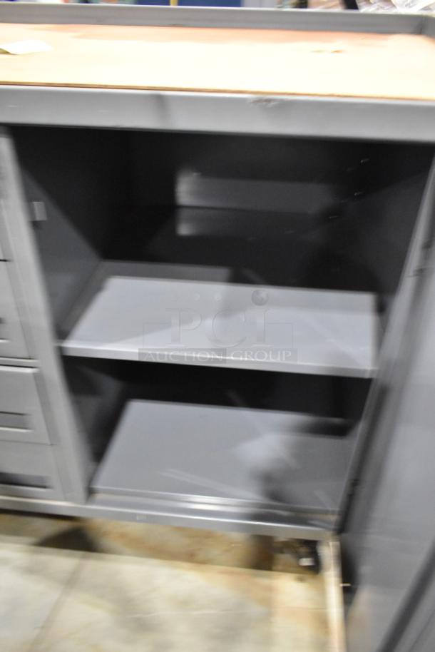 Gray metal cart with four drawers and door, on commercial casters. Appears in good condition.