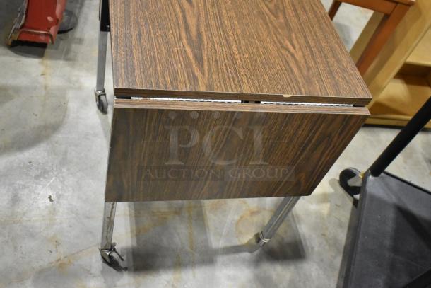 Wood pattern desk on casters with a sleek design. Appears in good condition, minimal wear. Suitable for office spaces.