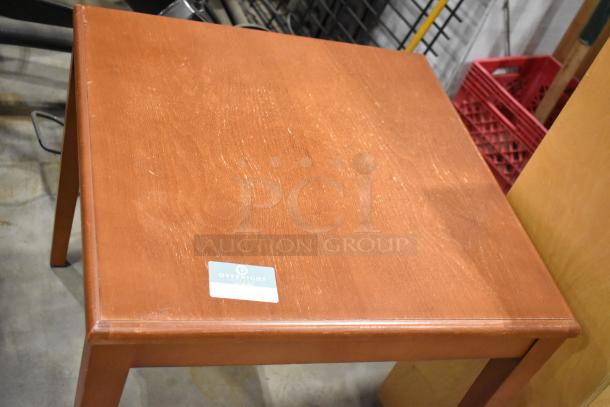 Wood pattern table with visible grain, square shape, good condition, features a "Overnight Table" label.