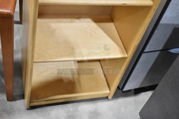 Wood pattern bookshelf with three shelves, minor wear. Part of a set including a desk on casters and a table. Includes label: "Kaplan."