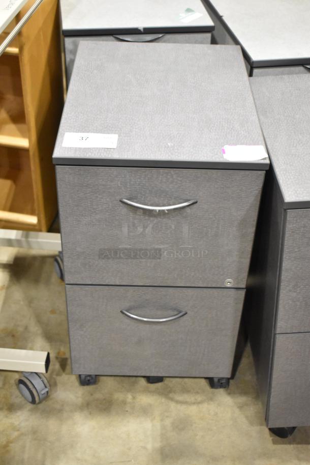 Gray 2-drawer filing cabinet on casters, labeled "37," with silver handles, in good condition. 4 available.