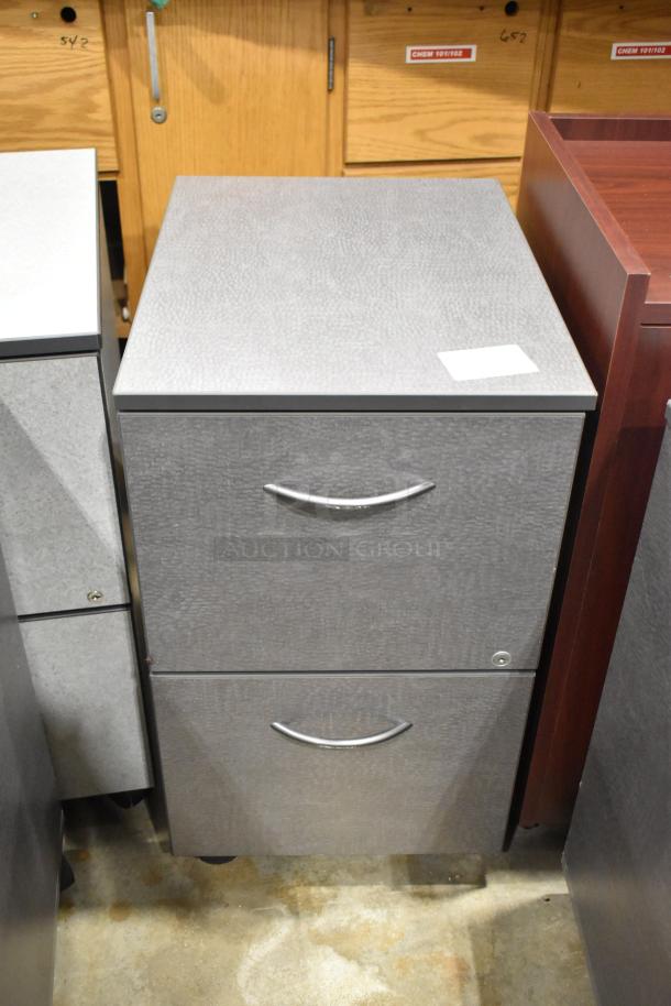 Gray 2-drawer filing cabinet with casters, metal handles, and textured finish. Part of a set including wood-pattern cabinet.
