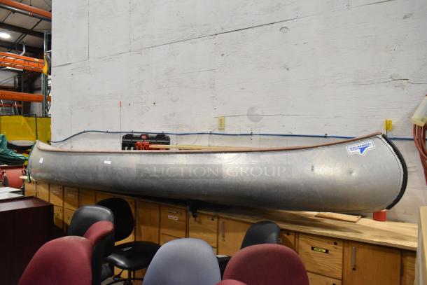 12' Grumman 13 CANOE metal canoe in good condition with oar and life jacket. Features Grumman logo.