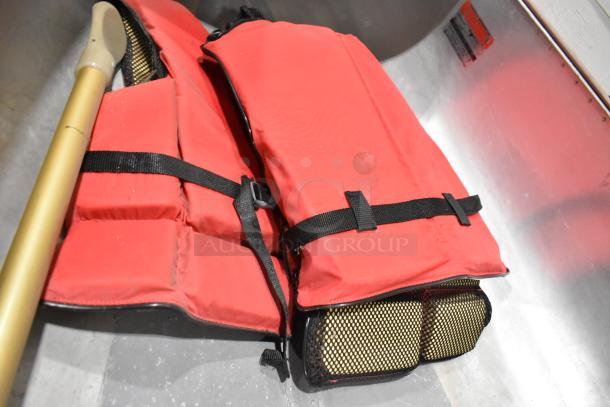 12' Grumman 13 CANOE metal canoe set with oar and red life jacket. Durable build, ideal for outdoor activities.