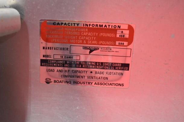 Grumman 13 Canoe metal tag showing capacity info: 3 max horsepower, 450 lbs person capacity, 590 lbs total weight.