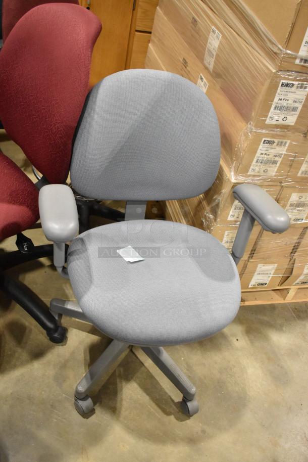 10 office chairs on casters in assorted colors, adjustable arms, gently used. Includes gray and red fabric variations.