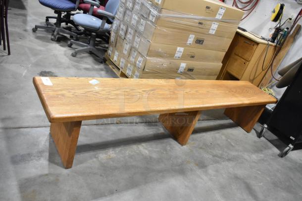 Wood pattern bench with a natural finish, featuring a smooth surface and sturdy legs. Excellent condition, ideal for seating.