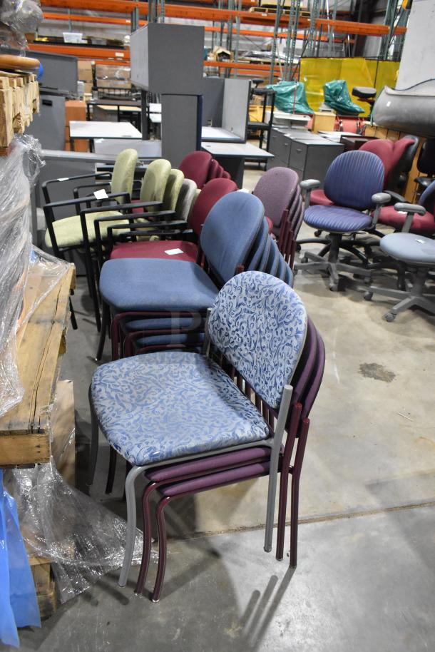 Assorted stackable office chairs, multiple colors, varying upholstery, metal frames, used condition, warehouse setting.