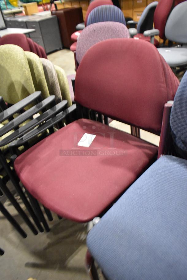 28 assorted office chairs in varied colors and conditions, including maroon, green, and blue, with armrests.