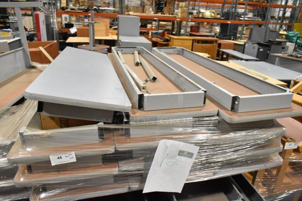 29 gray folding tables stacked, featuring durable surfaces and collapsible metal frames. Sold in bulk, new condition.