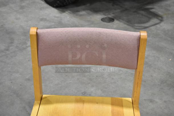 Wood chair with light wood frame and pink fabric backrest. Good condition. Auction for a set of eight chairs.