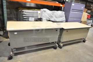 Two wood pattern desks on casters, beige finish, secure and mobile, slight wear, ideal for versatile office use.