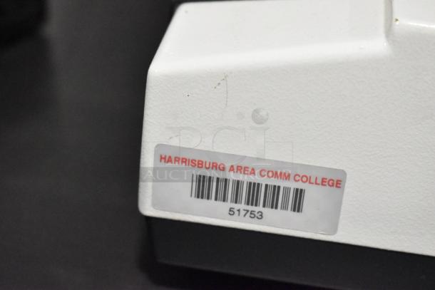 Black table with Pro Microscope XSZ-510D, 5 Head Multi-Viewing Teaching Microscope. Label: "Harrisburg Area Comm College."
