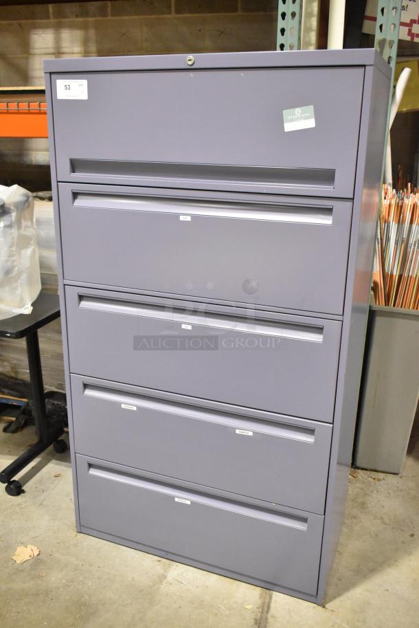 Metal filing cabinet with four drawers and one door, gray color, labeled compartments, key lock, good condition.