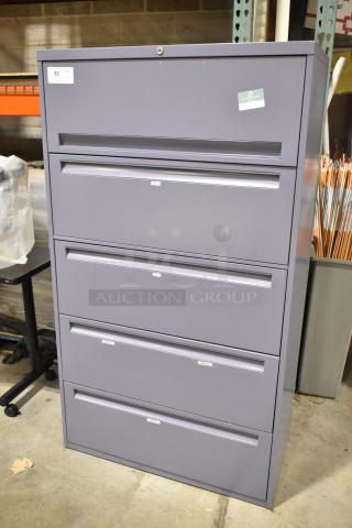 Metal filing cabinet with four drawers and one door, gray color, labeled compartments, key lock, good condition.