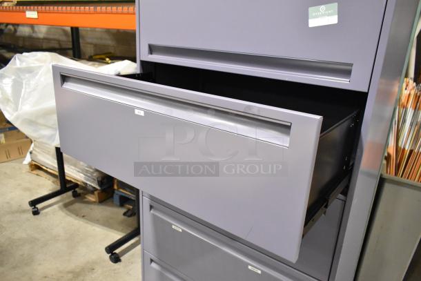 Metal filing cabinet with 4 drawers and 1 door, gray finish, open drawer, labeled "Overnight Office" at top.