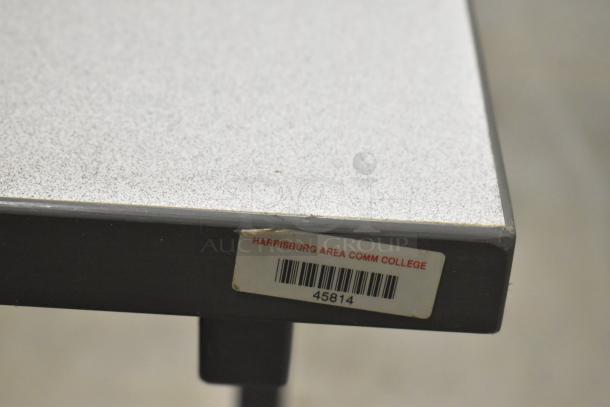 Two gray desks with a speckled surface. Tag reads "Harrisburg Area Comm College" with barcode 45814. Good condition.