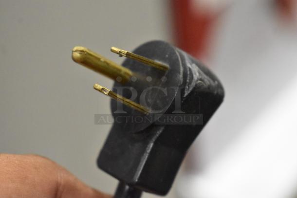 A close-up of a black three-prong power plug connector.