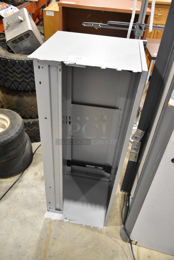 2 gray overhead desk cabinets, vertical orientation, metal construction, open back, excellent condition. Auction label visible.