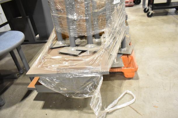 2 pallets of assorted items including tabletops and table legs, wrapped in plastic, good condition, warehouse setting.