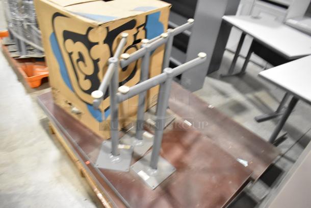 Two pallets with various items including gray table legs and boxed tabletop parts, suitable for customizable furniture projects.