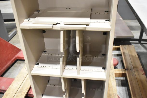Beige modular bookshelf with adjustable shelves, shown partially assembled on a warehouse floor.