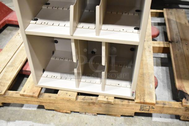 Metal bookshelf with adjustable dividers on a wooden pallet. Good condition, beige color. Marking visible: "1498U."