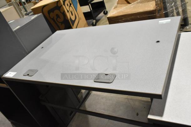 Three gray office desks, modern design, cable management features, minor wear visible, auction tag #123.