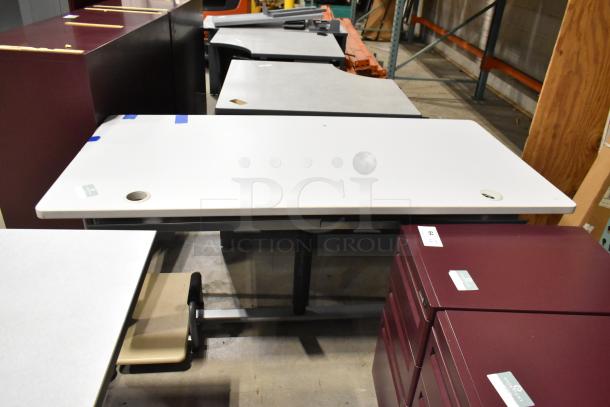 Three gray office desks in good condition, with cable management holes, ready for auction.