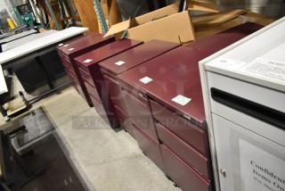 Six maroon metal filing cabinets, including 2-drawer and 3-drawer units, in good condition. Auction offers six times your bid.