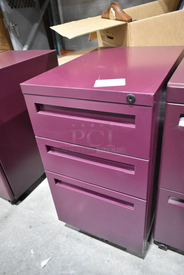Maroon metal filing cabinet with three drawers, lock mechanism, and sleek design. Part of a lot of six, in good condition.