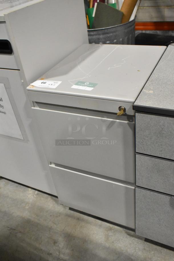 Two metal filing cabinets; one with 2 drawers, one with 3 drawers. Some wear, with locking mechanism and auction label visible.