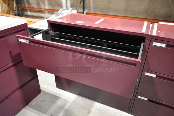 Two maroon metal 3-drawer filing cabinets, excellent condition, sleek design, label holders on each drawer.