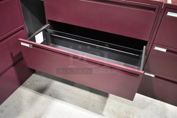 Maroon metal 3-drawer filing cabinet with open drawer, excellent condition, sturdy design, label areas visible.