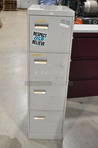 Gray metal four-drawer filing cabinet with stickers, visible wear, and scratches, ideal for office storage.