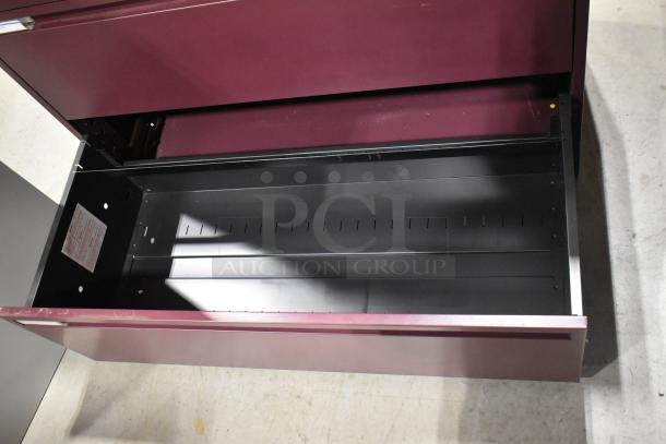 Maroon metal 3-drawer filing cabinet, open drawer view, sturdy construction, minor wear visible, perfect for office use.