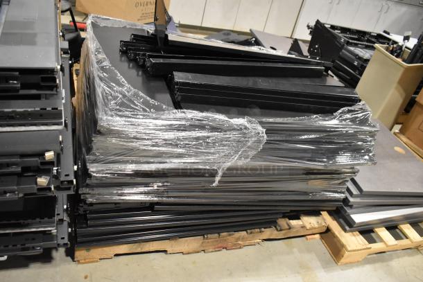 Six pallets of assorted items including metal pallet racking and gray desk panels, wrapped in plastic.