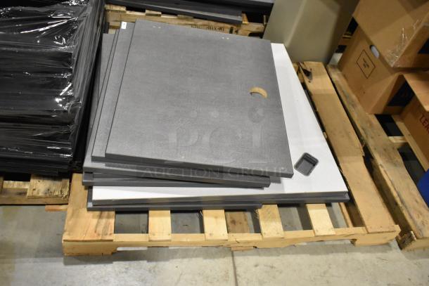 Six pallets of various items including metal pallet racking and gray desk panels, in good condition, resting on a warehouse floor.