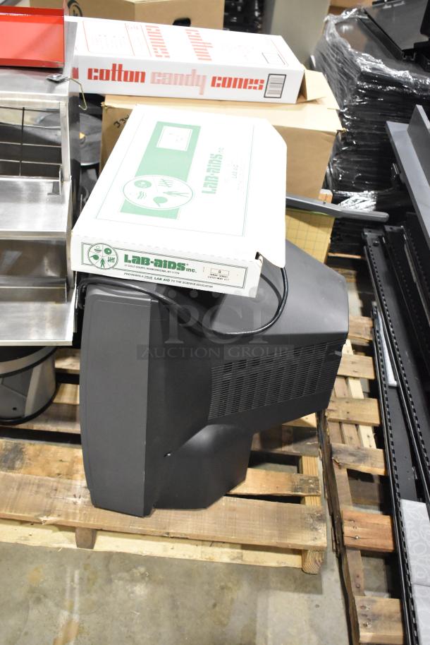 Pallet lot with assorted items: black television, metal hot dog merchandiser, Lab-Aids test tube holder, and cotton candy cones box.