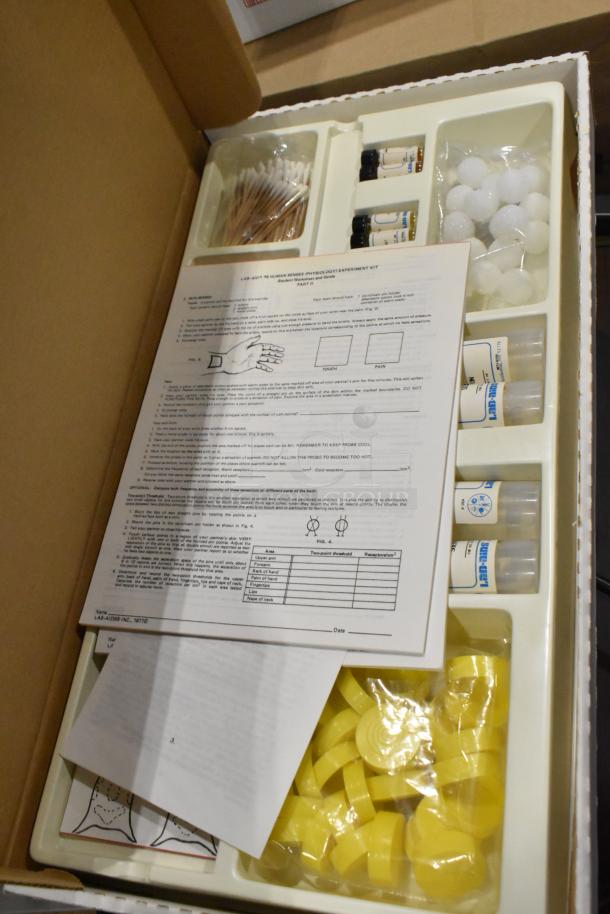 Open Lab-Aid kit with instructions, test tubes, and components for human senses physiology experiment.
