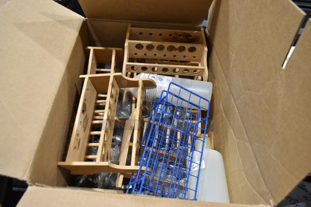 Pallet with wooden test tube holders, blue wire racks, and plastic bottles. Items appear in good condition.