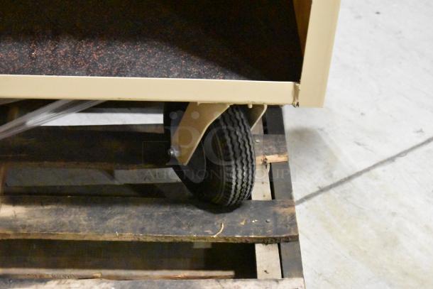 2-tier cart with sturdy casters, featuring a beige frame and black speckled shelves, in good condition.