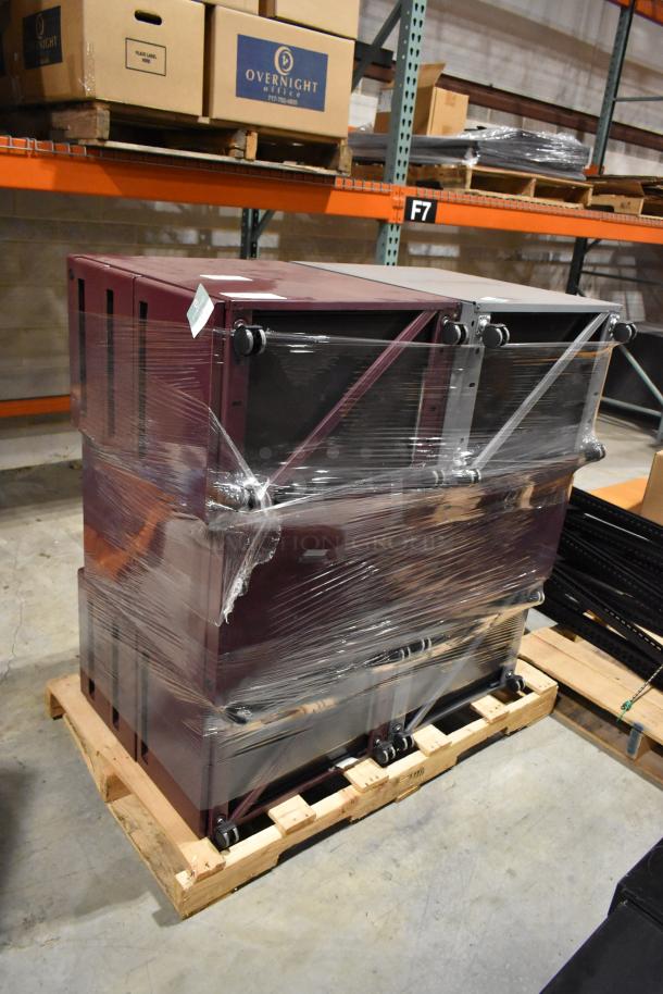 Stack of maroon and gray metal filing drawers, includes 3-drawer and 2-drawer units. Wrapped in plastic, stored on a pallet.