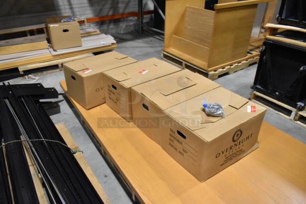 Three pallets of assorted metal pieces for racking, including various sized boxes on wooden pallets. Boxes labeled "Overnight Office."