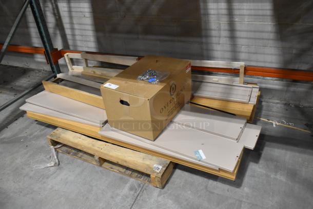 Pallet lot with various metal panels and a cardboard box labeled "Overnight." Items appear new with minor warehouse wear.