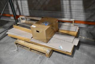 Pallet lot with various metal panels and a cardboard box labeled "Overnight." Items appear new with minor warehouse wear.