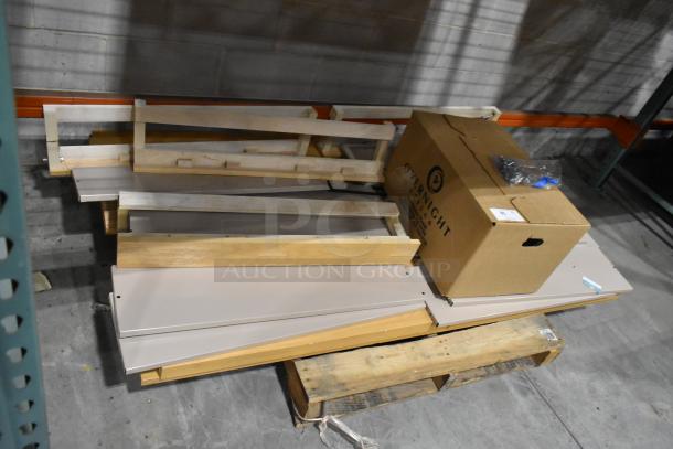Pallet of various items including wooden panels and metal pieces, with an "Overnight Office" labeled box on top.