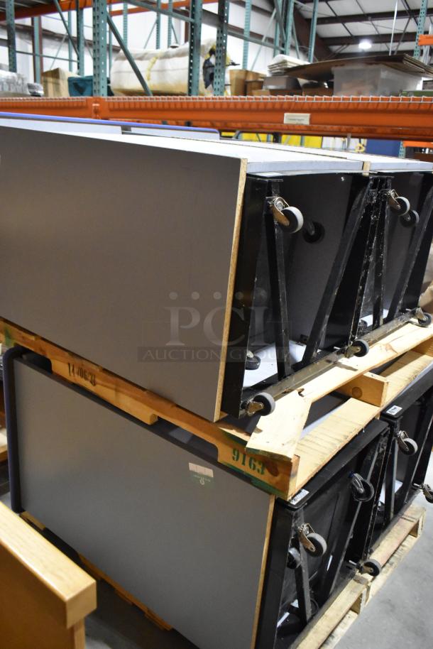 Gray double trash can shell on casters; sturdy construction, stackable, ideal for waste management systems.