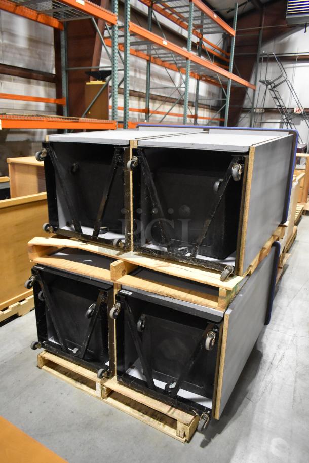 Two gray double trash can shells with casters, stacked on wooden pallets in a warehouse. Excellent condition.