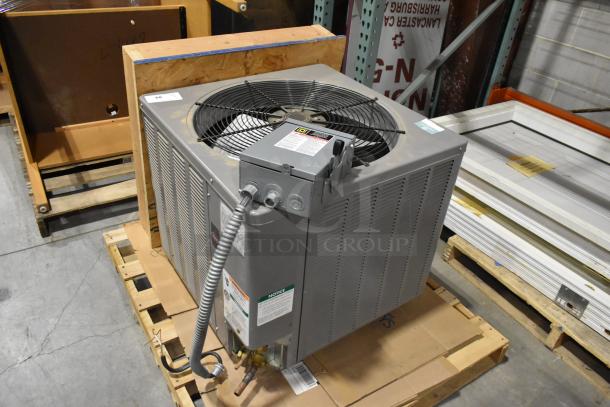 Rheem 13PJA24A01 metal air conditioner condenser. 208/230 volts, 1 phase. Appears in good condition. Features visible labeling.